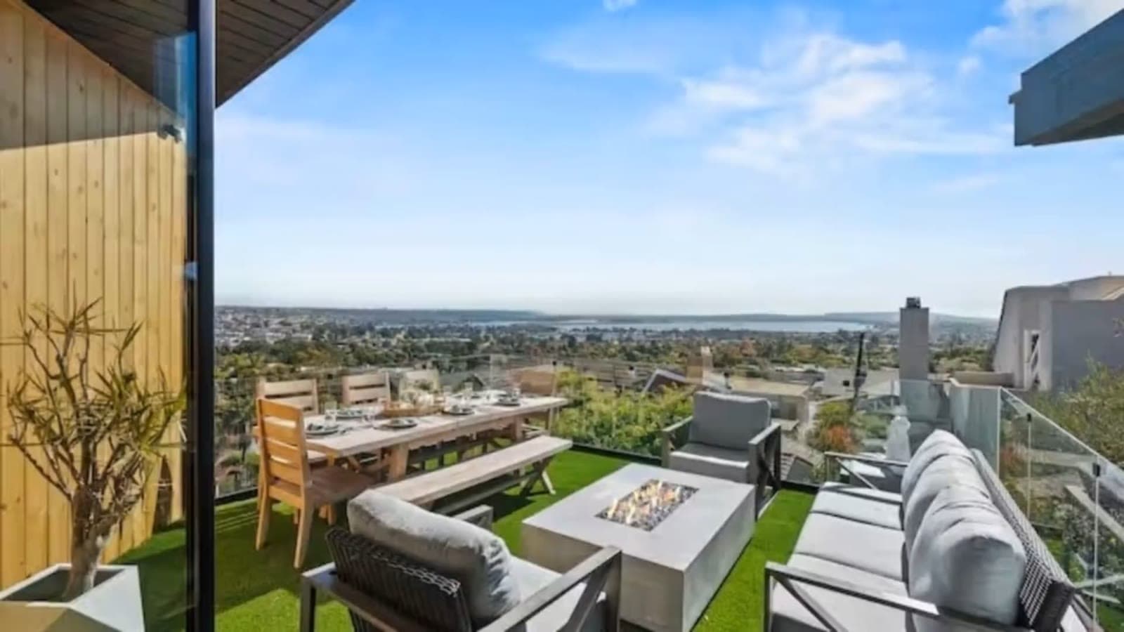Still from an example property walkthrough: outdoor seating on a terrace with a wide view of the water.